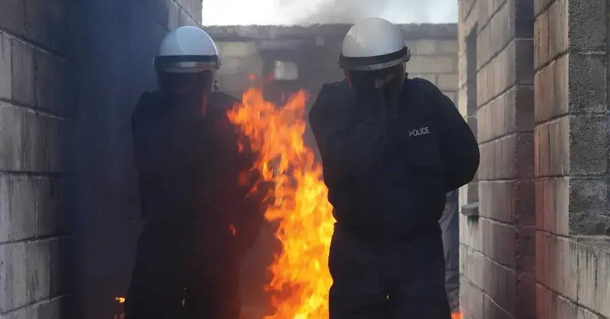 Two police officers running through fire. 