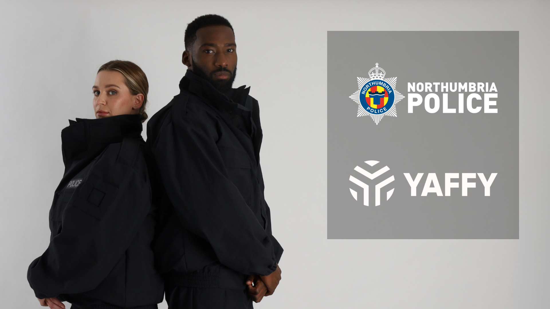 Two officers stood back to back wearing black PSU suit with Northumbria Police and Yaffy logo next to them.